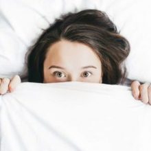 Understanding Weighted Blanket Therapy: How Does It Work? Girl covering herself with a blanket
